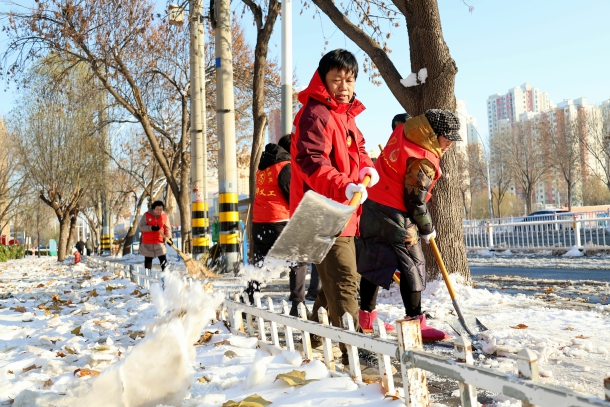 图为陈奇峰带领义工清理道路积雪 图为陈奇峰带领义工清理道路积雪
